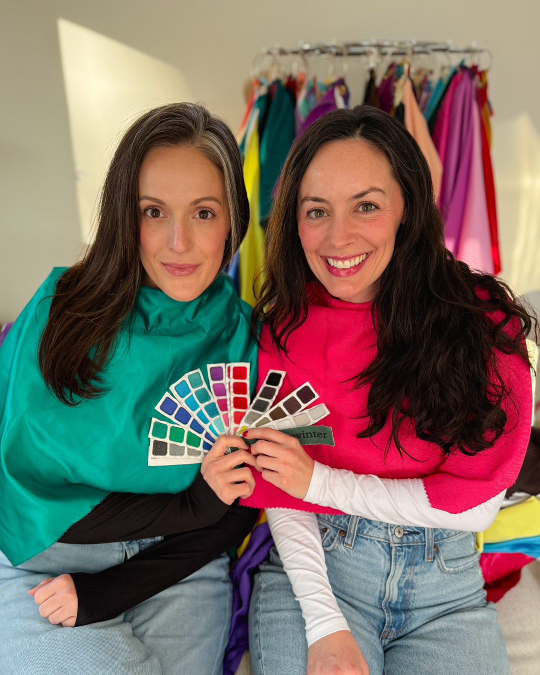 Two clients draped and holding their color fans